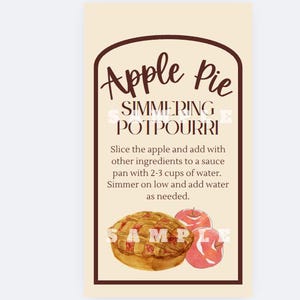 Może przedstawiać: Prostokątny znak z brązową obwódką z napisem "Apple Pie Simmering Potpourri". Zawiera instrukcje i akwarelowe ilustracje szarlotki i dwóch jabłek, idealne do aromatyzowania domu.