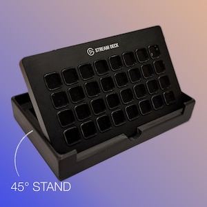 May include: Black Stream Deck with 32 square buttons, angled at 45 degrees in a stand. The Stream Deck logo and text are visible at the top. The stand is also black.