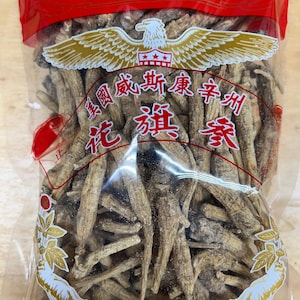 May include: A clear plastic bag filled with dried ginseng roots. The bag has a red background with a gold eagle logo and Chinese text that reads "Yu Fung Co.  Health Products".