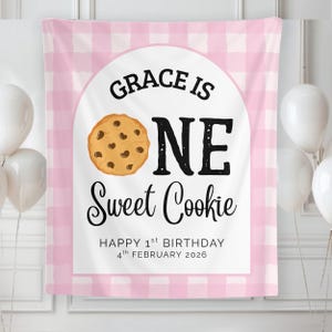 Może przedstawiać: Różowo-białe tło w kratkę z napisem "GRACE IS ONE Sweet Cookie" i grafiką ciasteczka z kawałkami czekolady. Zawiera również tekst "HAPPY 1st BIRTHDAY 4th FEBRUARY 2026".