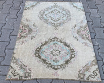 May include: A vintage rug with a cream background and a repeating pattern of brown, pink, and blue floral motifs. The rug has a distressed look and is perfect for adding a touch of bohemian style to any room.