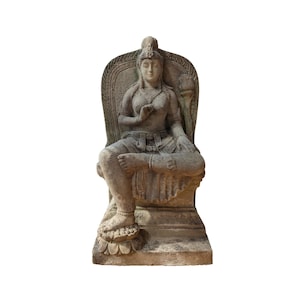 Op de afbeelding: Een stenen beeldhouwwerk van een zittend vrouwelijk figuur met een kroon, die een lange jurk draagt en een lotusbloem vasthoudt. Het beeldhouwwerk is in traditionele stijl gemaakt en is een prachtig voorbeeld van oude kunst.