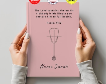 May include: A pink notebook with the text "The Lord sustains him on his sickbed; in his illness you restore him to full health. Psalm 41:3." A stethoscope graphic is centered below the text. The name "Nurse Sarah" is printed at the bottom.