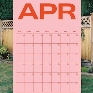 May include: A pink calendar for April with orange lettering and grid lines. The word "APR" is at the top, with days of the week across the top row. The calendar is set against a backdrop of green foliage and a wooden fence.