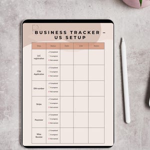 Könnte beinhalten: Ein digitaler Business-Tracker auf einem Tablet mit einem beige-weißen Design. Der Tracker enthält Abschnitte für LLC-Registrierung, ITIN-Antrag, EIN-Nummer, Stripe, Payoneer und Wise Revolut. Ein Stift und eine kleine Topfpflanze sind ebenfalls sichtbar.