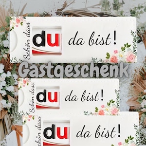 May include: Three white rectangular gift tags with floral accents and the text "du da bist!" in black script. The tags also feature the words "Sch&ouml;n dass" and "Gastgeschenk".