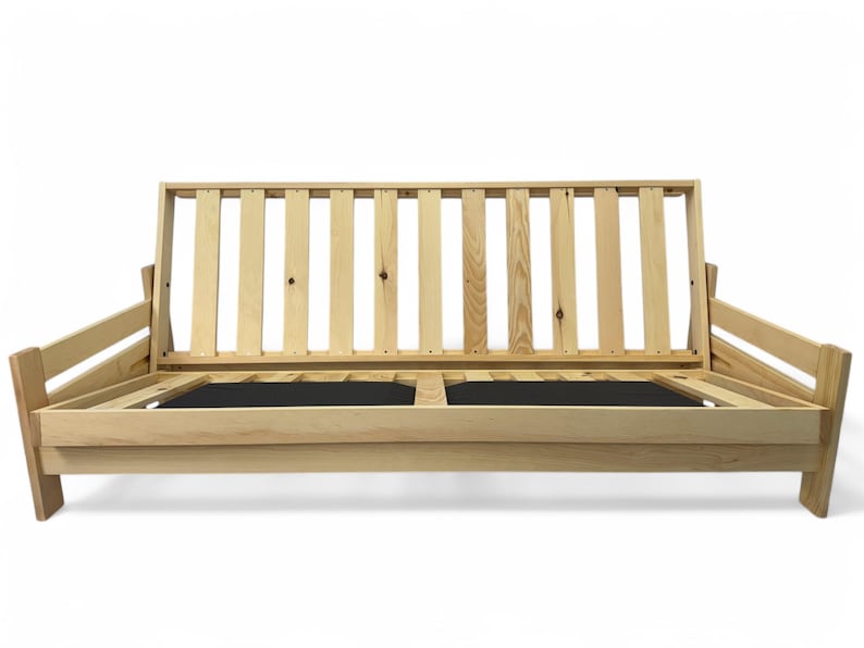 K&ouml;nnte beinhalten: Ein hellfarbiger Futonrahmen aus Holz mit Lattenr&uuml;cken und Armlehnen. Der Rahmen hat ein schlichtes, modernes Design und verf&uuml;gt &uuml;ber eine schwarze Basis. Der Futon ist so konzipiert, dass er sich in ein Bett verwandeln l&auml;sst.