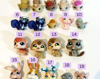 Puede incluir: Una colección de 19 pequeñas figuras de animales de plástico, numeradas del 1 al 19. Las figuras son de varios colores, incluyendo marrón, rosa, gris, blanco y azul. Están dispuestas en filas, con los números encima de cada figura.
