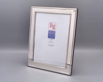 May include: Silver picture frame with a beveled edge and a white mat. The frame has a label that reads "Pg Miani Venezia".