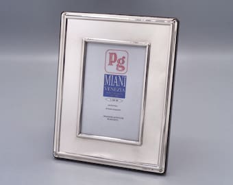 May include: Silver picture frame with a beveled edge and a black mat. The frame has a label that reads "Pg Miani Venezia".