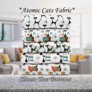 May include: A stack of fabric rolls with retro cat patterns. The designs include black cats, TVs, atomic shapes, and geometric patterns on a white background. The text "Atomic Cats Fabric" and "Choose Your Patterns" are displayed.