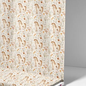 May include: A roll of fabric featuring a repeating pattern of watercolor-style ponies and wildflowers in shades of beige, brown, and yellow on a white background. The fabric is printed with "American Fabric Prints (C)".