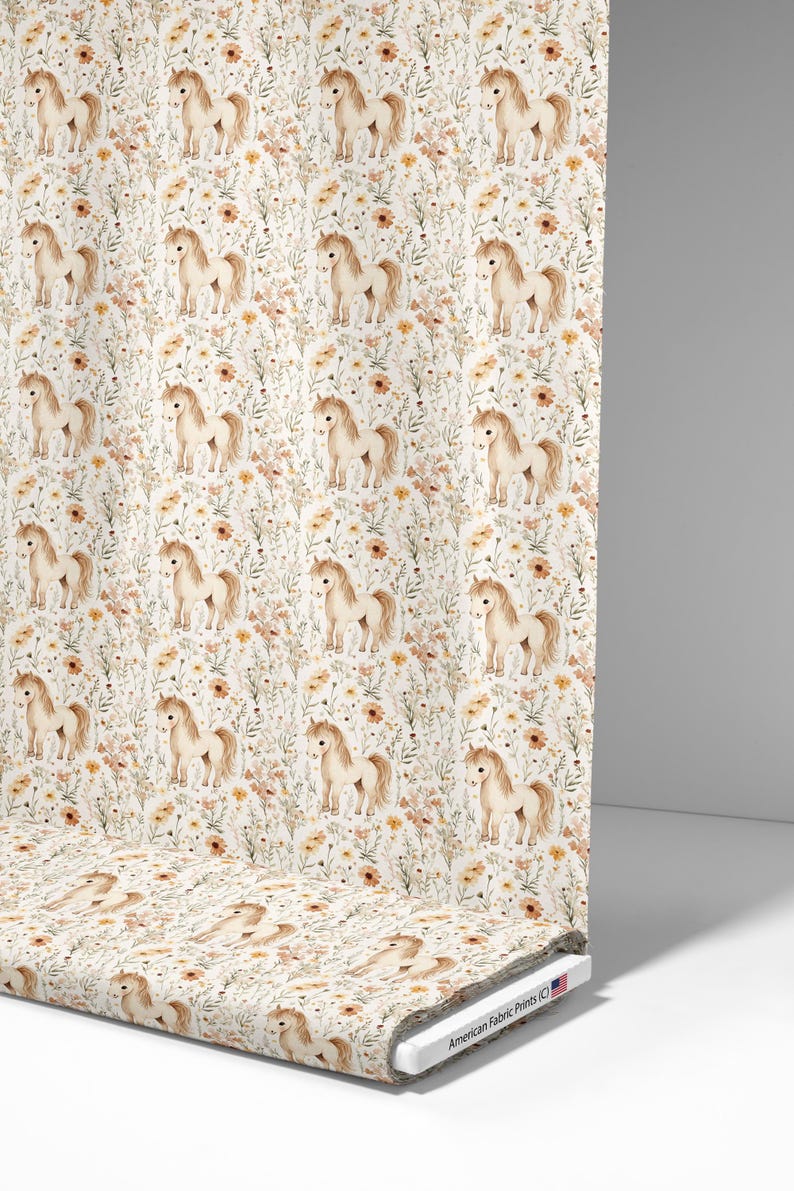 May include: A roll of fabric featuring a repeating pattern of watercolor-style ponies and wildflowers in shades of beige, brown, and yellow on a white background. The fabric is printed with "American Fabric Prints (C)".