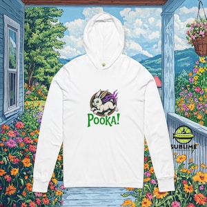 Puede incluir: Sudadera con capucha blanca con un gráfico de un conejo con llamas moradas y la palabra "Pooka!" en verde. La sudadera tiene una capucha con cordón y mangas largas. El diseño está centrado en la parte delantera.