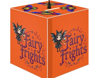 May include: Orange cube pendant lamp with a cartoon fairy and the text "Fairy & Frights" in purple. The top has colorful abstract designs. A black cord hangs from the top. The lamp is designed to be suspended from the ceiling.
