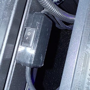 May include: A black electrical switch with a white toggle switch. The switch is mounted on a black plastic box.