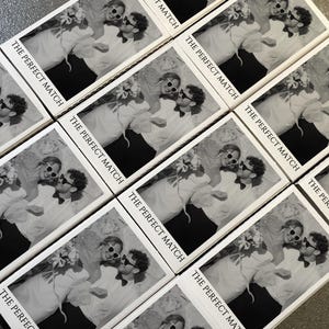 May include: A collection of matchboxes with a black and white image of a couple wearing sunglasses and holding flowers. The text "THE PERFECT MATCH" is printed on each box, suggesting a wedding or relationship theme.