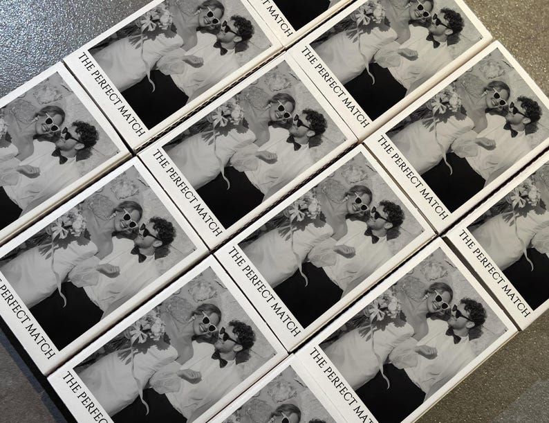 May include: A collection of matchboxes with a black and white image of a couple wearing sunglasses and holding flowers. The text "THE PERFECT MATCH" is printed on each box, suggesting a wedding or relationship theme.