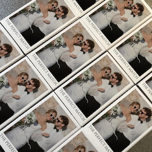 May include: Arrangement of rectangular cards featuring a couple wearing sunglasses, embracing, and holding flowers. The text "THE PERFECT MATCH" is printed on each card in a black, sans-serif font. The cards are arranged diagonally.