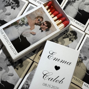 May include: White matchboxes with a black and white photo of a couple wearing sunglasses. The text "THE PERFECT MATCH" is printed on the box. The open box reveals red-tipped matches. A separate box has the names "Emma" and "Caleb" with a heart and the date "08.15.2026".
