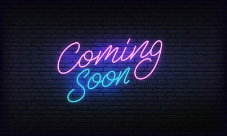 Peut inclure: Un panneau lumineux au n&eacute;on avec le texte "Coming Soon" en rose et bleu sur un fond de mur de briques noir.
