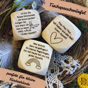 Könnte beinhalten: Holzwürfel mit verschiedenen Sprüchen für die Essenszeit. Die Würfel zeigen eine Raupe, einen Regenbogen, ein Herz und einen Text, der "Piep Piep Piep... wir haben uns alle lieb! Guten Appetit" lautet.