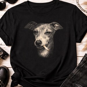 May include: Black t-shirt featuring a sepia-toned illustration of a dog with a cigarette in its mouth. The dog has a serious expression. The shirt is made of a soft material and has a classic crew neck.