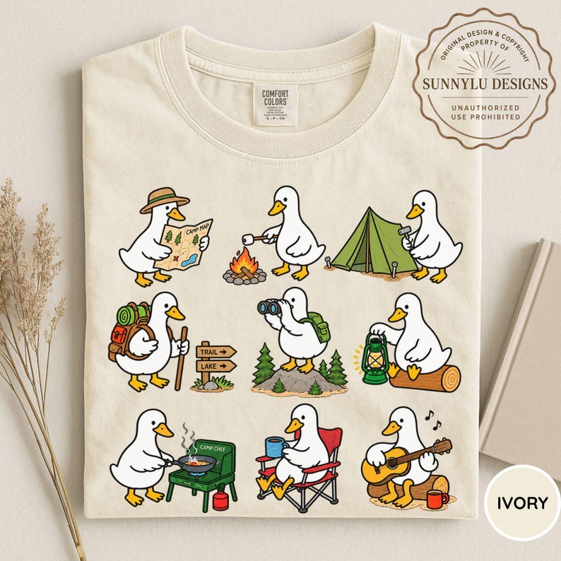 May include: An ivory t-shirt featuring a graphic print of nine white ducks engaged in various camping activities, including reading a map, roasting a marshmallow, setting up a tent, hiking, using binoculars, holding a lantern, cooking, and playing guitar.