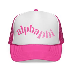 May include: A vibrant pink trucker cap with a white front panel. The curved peak and mesh back are also pink. The word "alphaphi" is printed across the front in a matching pink script.