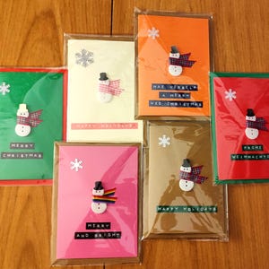 Bonita tarjeta navideña personalizada tamaño A6 hecha a mano con sobre, muñeco de nieve con botón, saludo personalizado, siete colores, interior en blanco