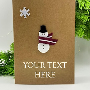 Tarjeta navideña A6 personalizada hecha a mano con sobre, muñeco de nieve con botón y saludo personalizado en blanco en el interior.