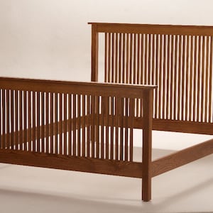 May include: A wooden bed frame with a headboard and footboard. The frame is made of brown wood and features vertical slats. The bed frame is designed with a simple, yet elegant style, suitable for a bedroom.