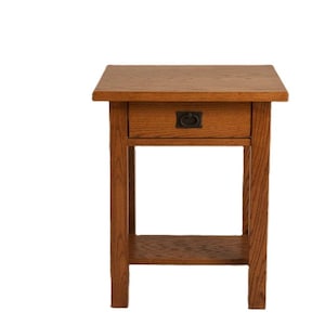 May include: A small, square wooden side table with a drawer and a lower shelf. The table is made of light brown wood and has a dark metal handle on the drawer. The table is 24 inches tall.