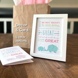 May include: A white framed print with the text "BE NOT WEARY in well-doing" and the word "GREAT" in pink. The print features two blue elephants. A matching card and a brown paper bag are also in the image.