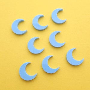 May include: Eight light blue crescent moon shapes on a yellow background.