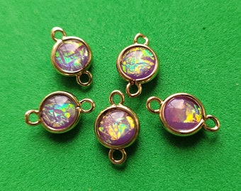 May include: Five gold-tone metal connector charms with iridescent purple and green glass cabochons. Each charm has two loops for attaching to jewelry.