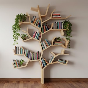 Op de afbeelding: Een houten boomvormige boekenplank aan een witte muur, gevuld met boeken in verschillende kleuren. De boekenplank heeft meerdere takken en planken, met kleine potplanten die een vleugje groen toevoegen. Het ontwerp is modern en artistiek.