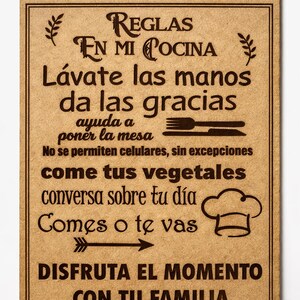 Puede incluir: Un letrero rectangular de madera con un asa recortada en la parte superior. El letrero presenta texto en español, incluyendo "REGLAS EN MI COCINA" y otras instrucciones relacionadas con la cocina. Los elementos decorativos incluyen hojas, un gorro de chef y una flecha.