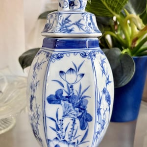 May include: A white ceramic mug with a black handle and the text "But First, Coffee" in a bold, black font. The mug is set against a neutral background, highlighting its simple design.