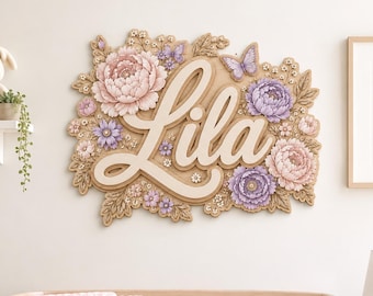 May include: A decorative wall sign featuring the name Lila in large, cream-coloured script lettering. The sign is surrounded by intricate, carved-style floral arrangements in shades of soft pink and lavender, accented with small butterflies.