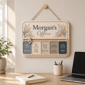 May include: A rectangular wooden office status sign with a rope hanger, featuring the text Morgan's Office. It includes a sliding heart-shaped marker to indicate status options: Available, With Client, On a Call, In a Meeting, and Away, with icons.