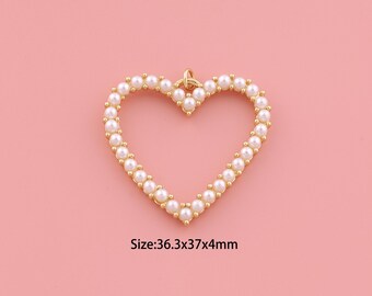 May include: A gold-colored heart-shaped pendant, outlined with small, round, white pearls. The pendant has a small loop at the top for hanging. The text "Size: 36.3x37x4mm" is below the pendant. The background is a solid pink.