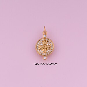 May include: Gold-toned pendant featuring a bee with a crown, surrounded by clear cubic zirconia stones. Size: 22x12x2mm.