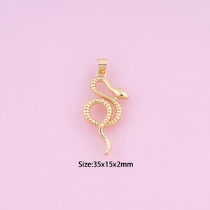 May include: Gold-toned snake pendant charm. The snake is curled up with its head facing to the right. Size: 35x15x2mm.