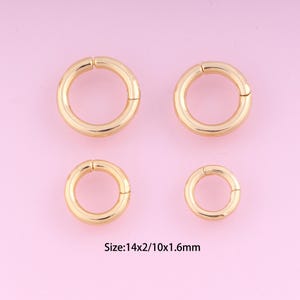 May include: Four gold jump rings of different sizes. The rings are open and have a smooth finish. The largest ring measures 14mm in diameter, the smallest ring measures 10mm in diameter. Size: 14x2/10x1.6mm