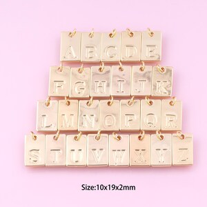 May include: Gold-toned alphabet letter charms, each letter is on a separate rectangular charm. The charms are arranged in three rows, with the letters A through Z. The charms are approximately 1.0 cm x 1.9 cm x 0.2 cm in size. Size: 10x19x2mm