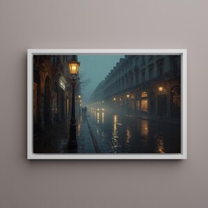May include: A framed print of a rainy street scene. The image shows a European street with buildings, streetlights, and reflections on the wet pavement. The scene is illuminated by the warm glow of the streetlights and shop windows.