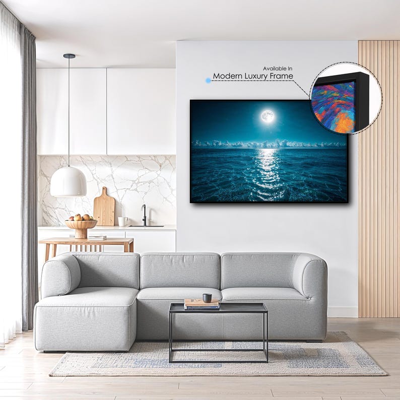 May include: A framed wall art print depicting a moonlit ocean scene with a bright moon reflecting on the water. The artwork is displayed in a modern luxury frame. The image is in a living room setting with a gray sectional sofa.