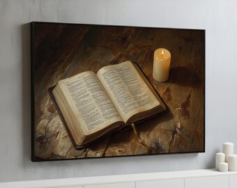 May include: A framed print depicts an open book with text, a lit candle, and a bookmark. The book has a brown leather cover and is set on a wooden surface. The candle is white and has a yellow flame.