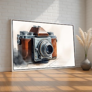 May include: A framed print of a vintage camera. The camera has a brown leather body, silver metal details, and a prominent lens. The print is displayed on a white background, with a white frame, and is set against a brick wall and wooden floor.